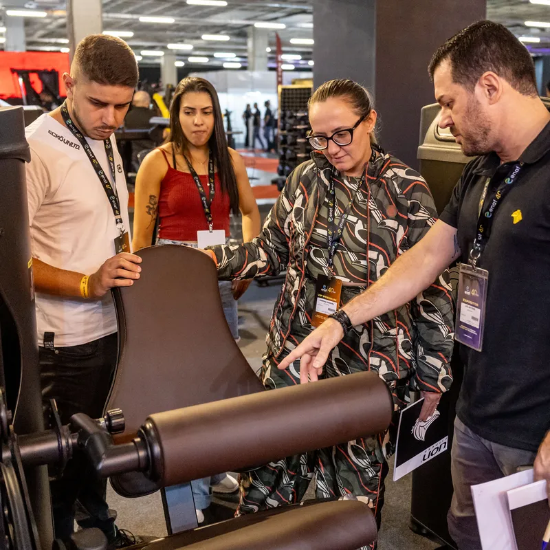 Visitantes conhecendo um equipamento com o expositor