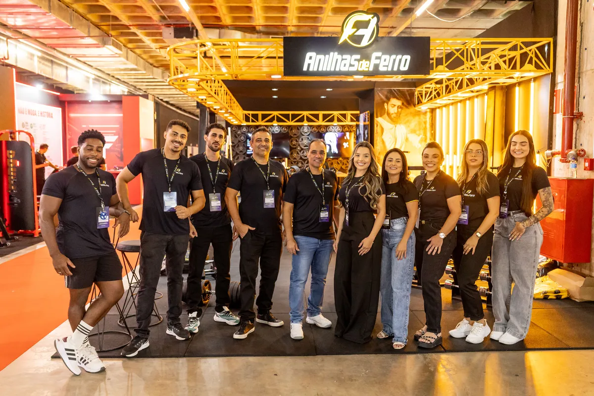 Equipe de uma marca expositora reunida no estande, sorrindo